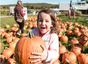 Girl holding pumpkin at Isham Farm Fall Festival